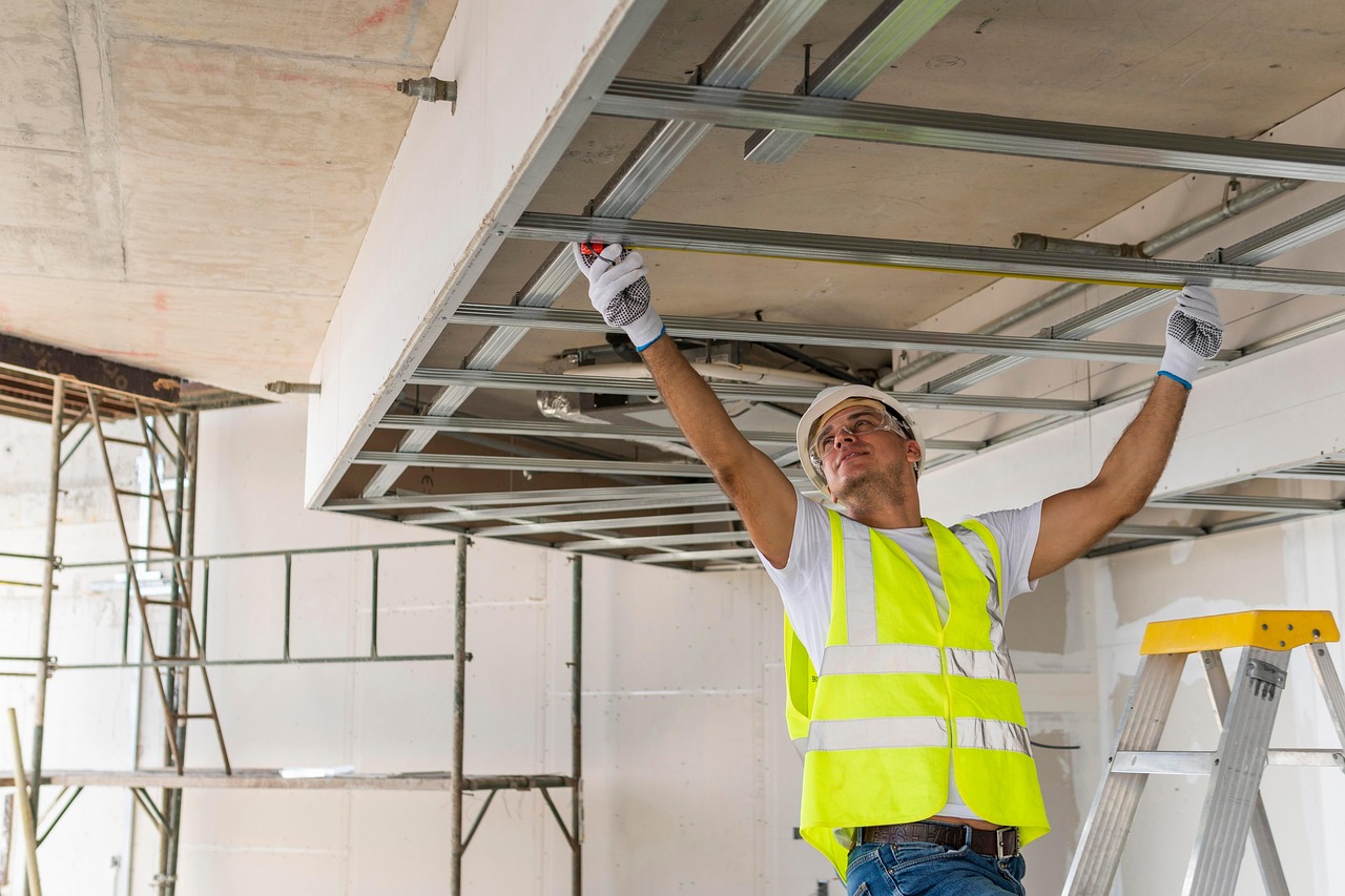 Technician fitting a ceiling frame during an interior repair job
